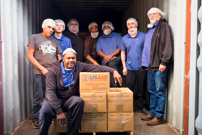 Staff at Breedlove Foods&#039; Lubbock plant loading food into a shipping container.