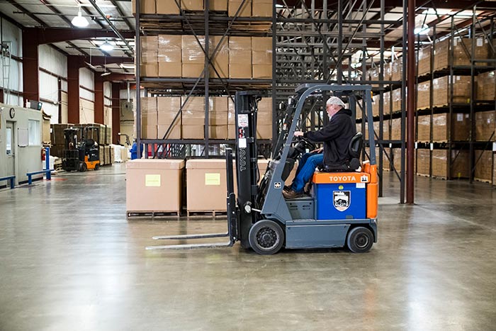 Breedlove staff operate a forklift in preparation for an aid shipment of nutritious food packs.