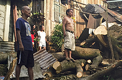 Men standing in storm and flood wreckage.