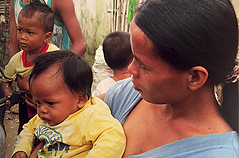 Mother with several small children in jungle village location.